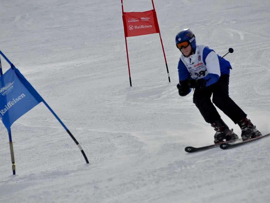 Skifahrer in der Kurve zwischen blauem und rotem Tor.